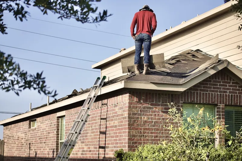 Professional roofer working on a residential roof in Airport-Pines Road